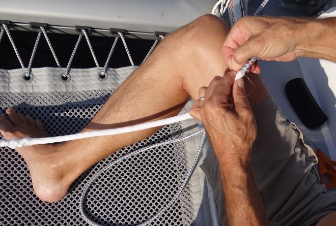 Attaching the protective sleeve over frayed section of jib furl line.