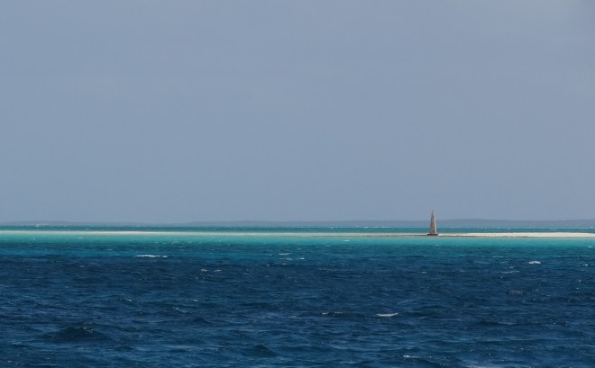 Very large sand bar marked with a stone beacon.