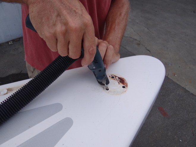 Ortolan's master repair guy dremels out the screw holes for the port bow pulpit