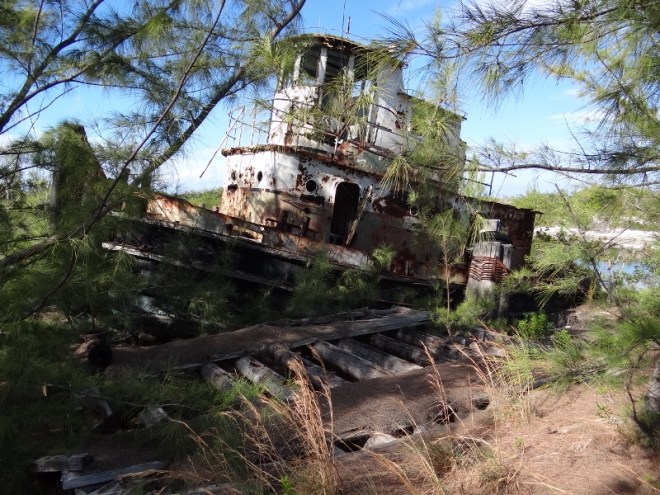 Tug still tied to its dock- the water now replaced by sand
