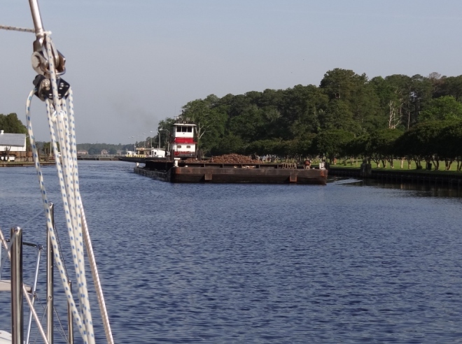 Tug and barge pass by after exiting the lock. 
