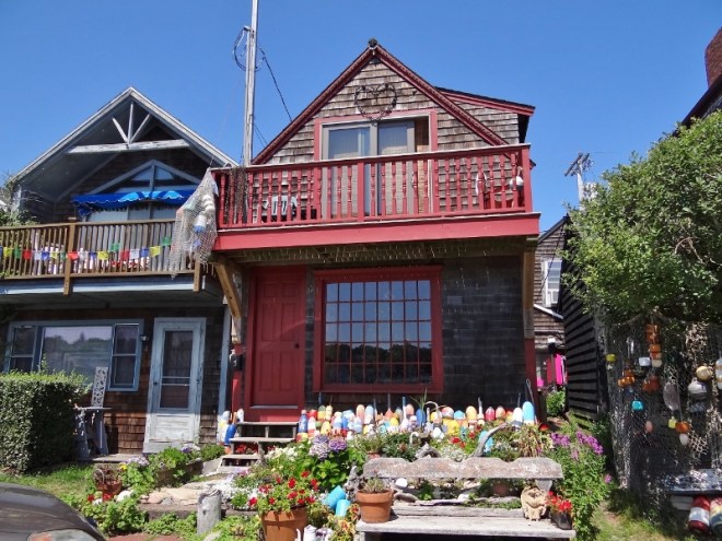 Pretty bungalows sit behind Bearskin Neck shops with a harbor view
