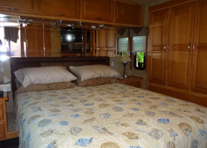 Bedroom with new quilt, blanket and sheets. The entire closet and drawers below, to the right, slides in and out.