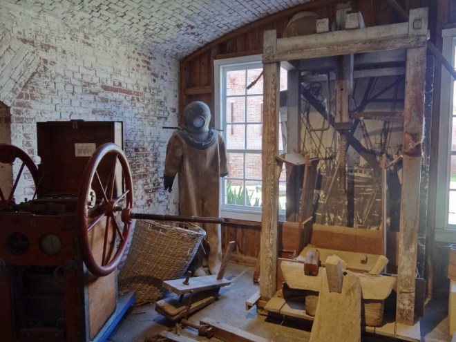 1940s -the early years of diving suits and air pump to the left