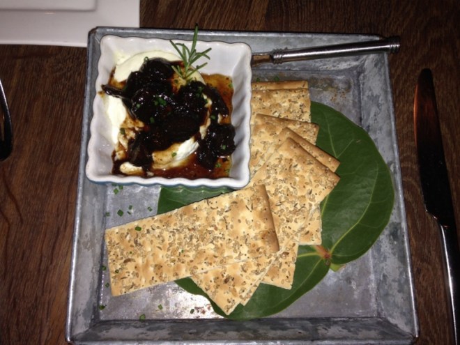 Lori's first course- warm goat cheese with honey-fig balsamic, mixed seeds flatbread crackers on SeaGrape leaves. Square plate of course